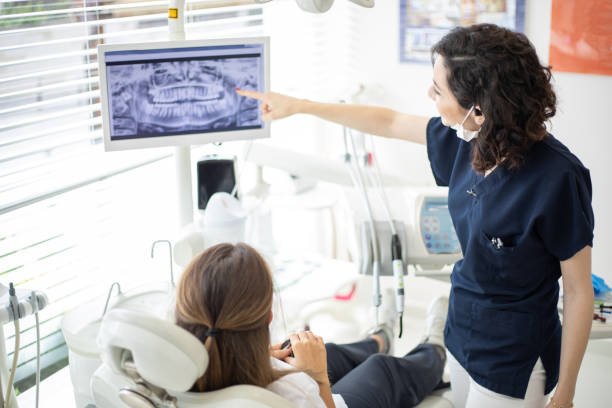 Female dentist talking to her patient at dentist's office